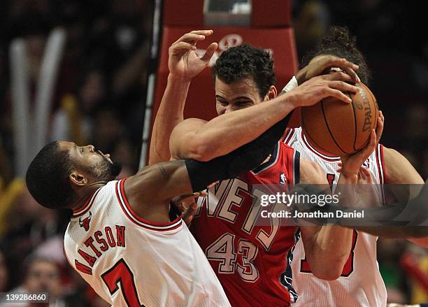 Watson of the Chicago Bulls gets his hand on the ball as Kris Humphries of the New Jersey Nets grabs a rebound at the United Center on February 18,...