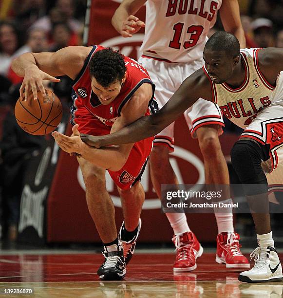 Loul Deng of the Chicago Bulls tries to knock the ball away from Kris Humphries of the New Jersey Nets at the United Center on February 18, 2012 in...