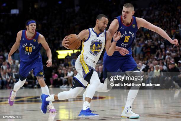 Stephen Curry of the Golden State Warriors drives against Nikola Jokic of the Denver Nuggets in the fourth quarter during Game Three of the Western...