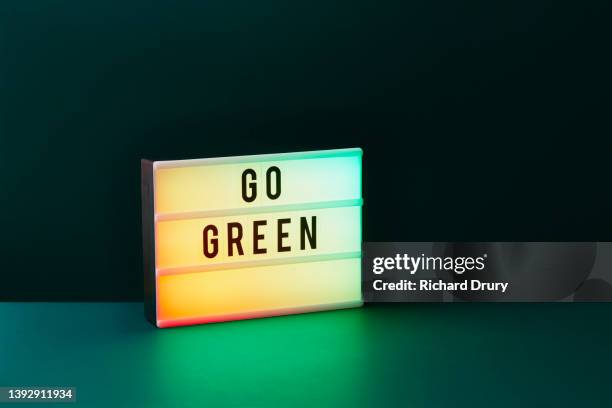 'go green' slogan on a lightbox - panel de luz fotografías e imágenes de stock