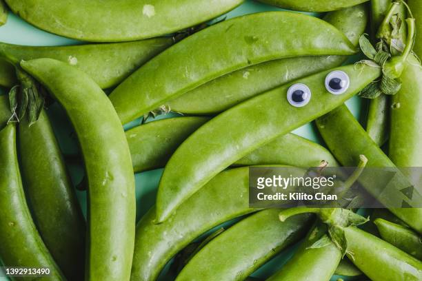 full frame shot of green pea with googly eyes - kawaii food stock pictures, royalty-free photos & images