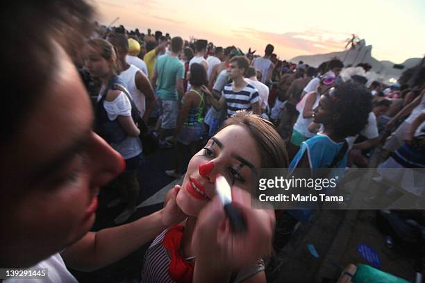 Man paints a woman's face during Carnival celebrations along Ipanema beach on February 18, 2012 in Rio de Janiero, Brazil. Carnival is the grandest...