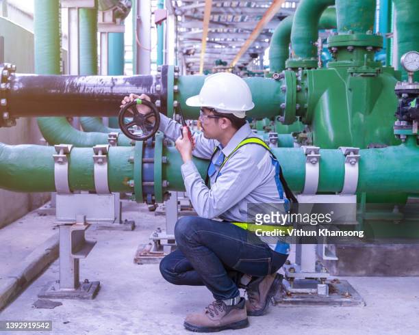engineer working at factory with pipeline and pump, operator operation of oil and gas process at power plant, operator monitor production process, routine daily work ,water pipe. - oil rig engineers stock pictures, royalty-free photos & images
