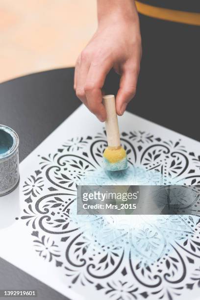 person using a dabber with acrylic paint on a mandala stencil - stencil fotografías e imágenes de stock