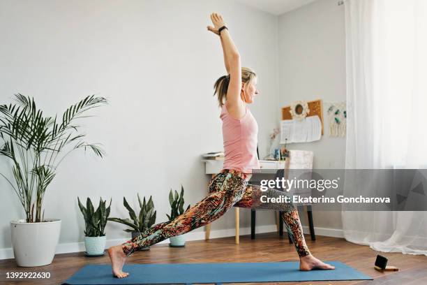 a woman is engaged in home fitness - yoga pose stockfoto's en -beelden