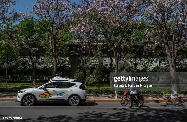 An Apollo robotaxi that is part of Baidu's Apollo Go autonomous ride-hailing service drives on the road in a demonstration area during a media tour...