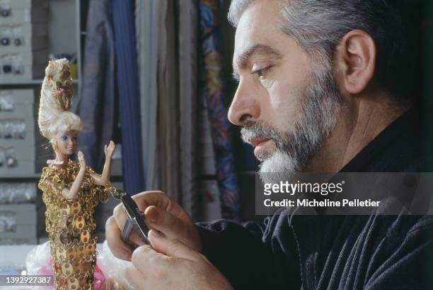 Spanish fashion designer Paco Rabanne dressing a Barbie doll in a miniature version of his celebrated metal mail outfits for Barbie's 30th...