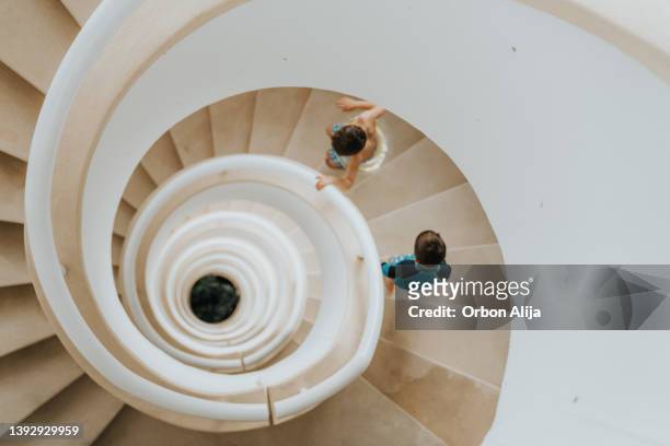 niños caminando por la escalera - spiral staircase fotografías e imágenes de stock
