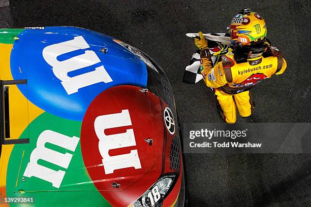 Kyle Busch, driver of the M&M's Brown Toyota, celebrates with the checkered flag after winning the NASCAR Budweiser Shootout at Daytona International...