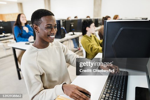 Jovem estudante africano usando computador dentro da sala da faculdade na universidade da escola - Foco no rosto Jovem estudante africano usando computador dentro da sala da faculdade na universidade da escola - Foco no rosto