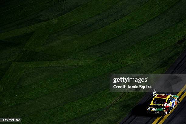 Kyle Busch, driver of the M&M's Brown Toyota, celebrates with the checkered flag after winning the NASCAR Budweiser Shootout at Daytona International...