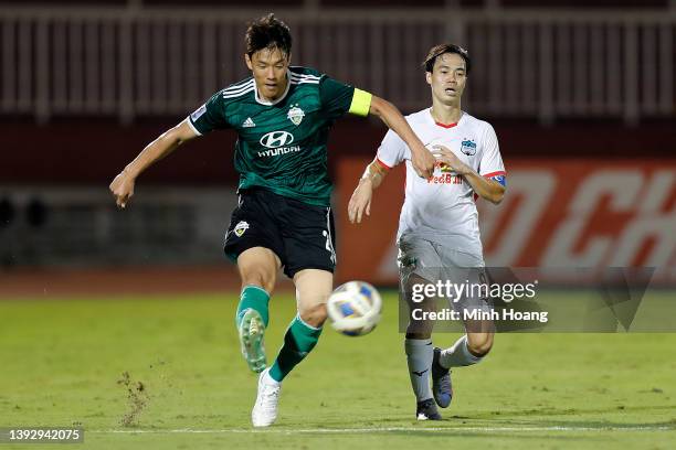 Hong Jeong-Ho of Jeonbuk Hyundai Motors passes the ball against Nguyen Van Toan of Hoang Anh Gia Lai during the first half of the AFC Champions...