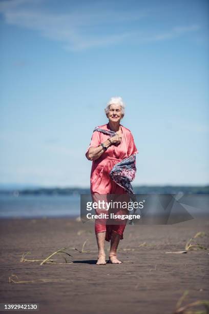 85-jährige frau genießt eine reise am strand - 80 89 years stock-fotos und bilder