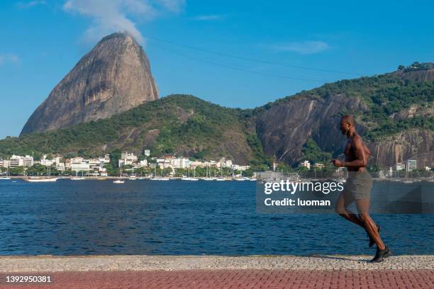 l'atleta corre sulle rive della baia di guanabara - running shorts foto e immagini stock
