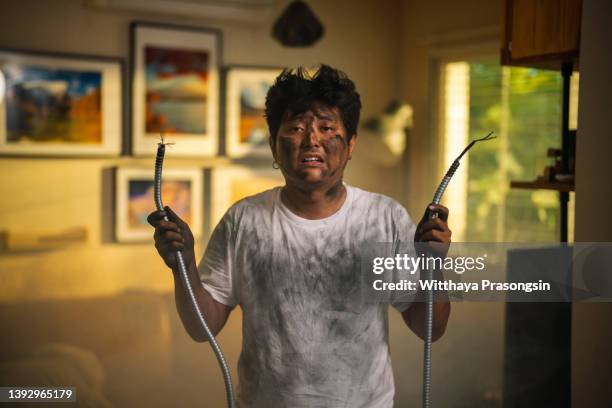 man gets a shock with his home - silla electrica fotografías e imágenes de stock
