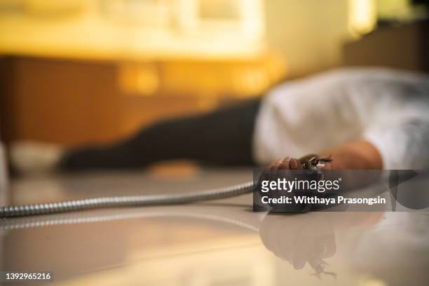 man electrocuted, lying injured on a household floor - electrical shock stockfoto's en -beelden