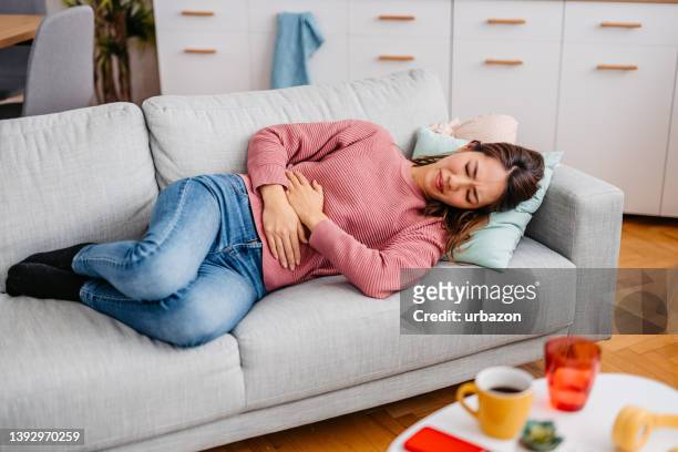 young woman having period cramps - diarrhea stock pictures, royalty-free photos & images