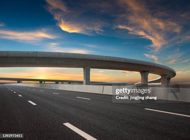 asphalt road of a crossover overpass under a clear sky in the evening - bridge low angle view stock pictures, royalty-free photos & images