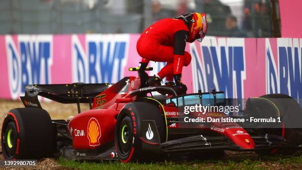 Carlos Sainz of Spain and Ferrari climbs from his car after crashing during qualifying ahead of the F1 Grand Prix of Emilia Romagna at Autodromo Enzo...