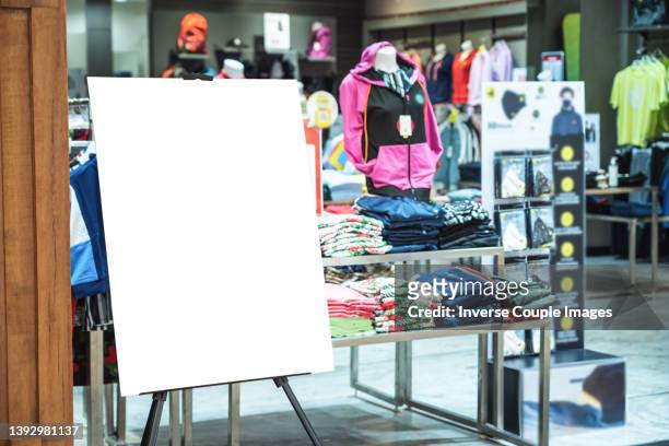 advertisement blank paper board in department store - sportswear shopping stock-fotos und bilder
