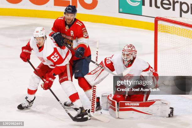 Jonathan Huberdeau of the Florida Panthers gets into position between goaltender Alex Nedeljkovic and Danny DeKeyser of the Detroit Red Wings at the...