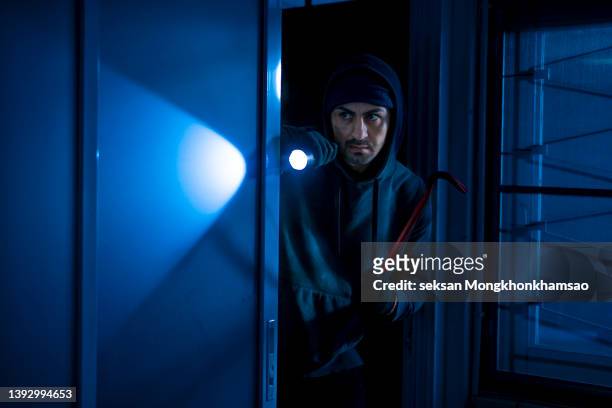 robber breaks house door - one man only stock pictures, royalty-free photos & images