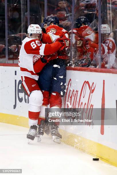 Danny DeKeyser of the Detroit Red Wings checks Sam Reinhart of the Florida Panthers into the boards at the FLA Live Arena on April 21, 2022 in...