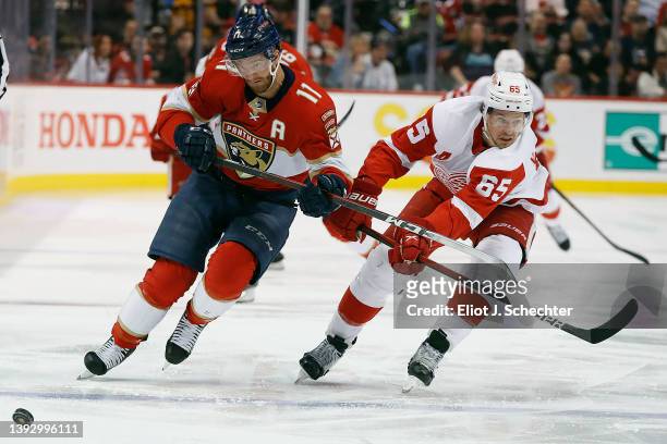 Jonathan Huberdeau of the Florida Panthers skates for possession against Danny DeKeyser of the Detroit Red Wings at the FLA Live Arena on April 21,...