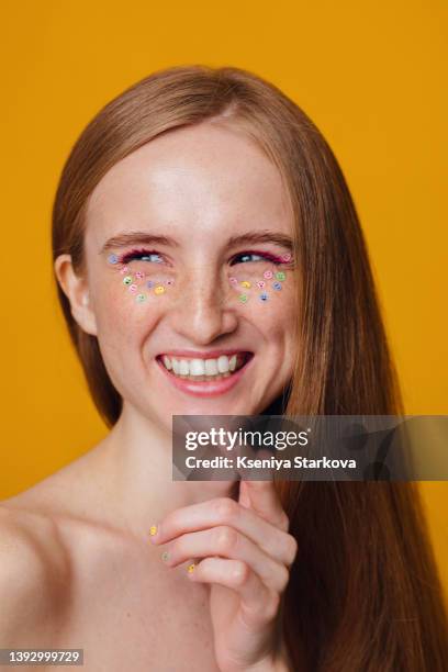 young beautiful european woman with blond hair and freckles on yellow looks away and laughs - only young women stock pictures, royalty-free photos & images