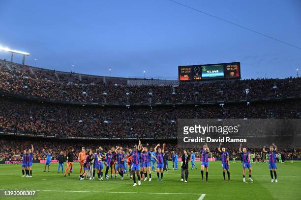 Barcelona players celebrate victory, with a new attendance record for a women's football match displaying on an LED board, following the UEFA Women's...