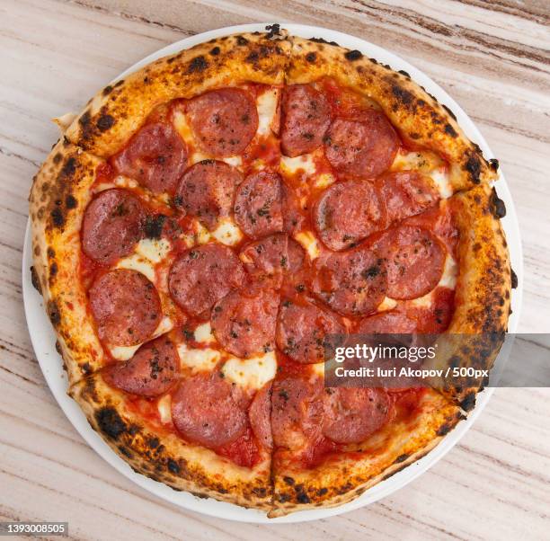 pizza,high angle view of pizza on table - pepperoni pizza stockfoto's en -beelden