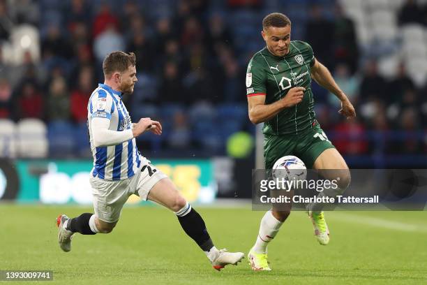Oliver Turton of Huddersfield Town and Carlton Morris of Barnsley battle for the ball during the Sky Bet Championship match between Huddersfield Town...