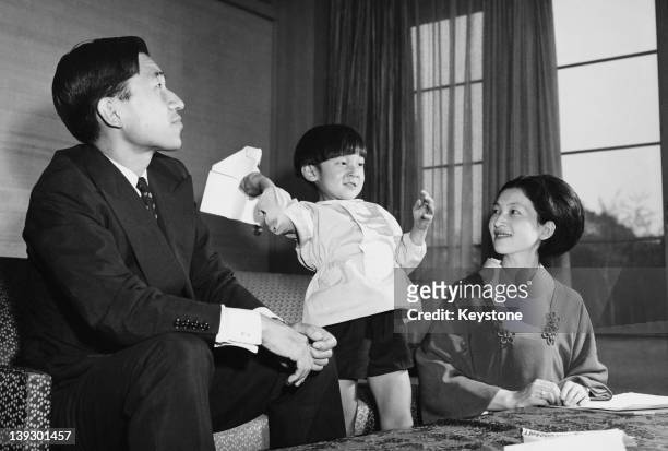 Crown Prince Akihito of Japan and Crown Princess Michiko with their son Prince Hiro, aka Crown Prince Naruhito of Japan, making paper aeroplanes on...