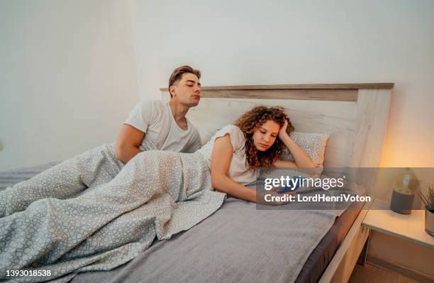 boyfriend is peeking in his girlfriend's phone - envy stockfoto's en -beelden