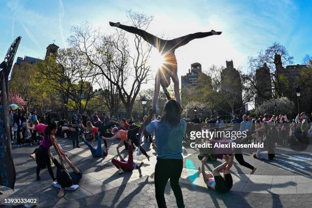 Acro-yogis celebrate Earth Day by participating in a flash mob in Washington Square Park on April 22, 2022 in New York City. The event, organized by...