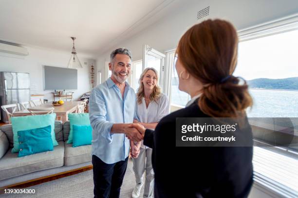 real estate agent showing a mature couple a new house. - luxury property bildbanksfoton och bilder