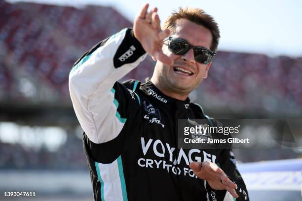 Landon Cassill, driver of the Voyager Crypto Debit Card Chevrolet, talks on the grid during qualifying for the NASCAR Xfinity Series Ag-Pro 300 at...