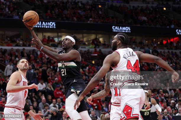 Jrue Holiday of the Milwaukee Bucks drives between Nikola Vucevic and Patrick Williams of the Chicago Bulls during the second quarter of Game Three...