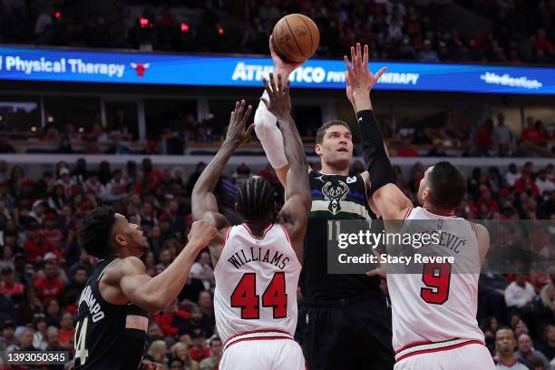 Brook Lopez of the Milwaukee Bucks shoots over Patrick Williams and Nikola Vucevic of the Chicago Bulls during the second quarter of Game Three of...