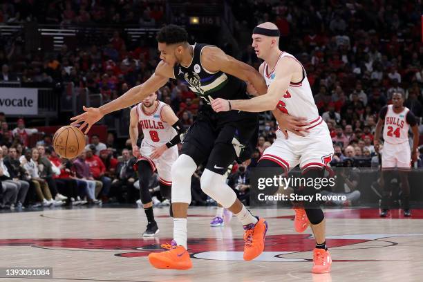 Giannis Antetokounmpo of the Milwaukee Bucks is defended by Alex Caruso of the Chicago Bulls during the second quarter of Game Three of the Eastern...