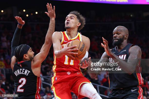 Trae Young of the Atlanta Hawks goes up for a layup against Gabe Vincent and Dewayne Dedmon of the Miami Heat during second half in Game Three of the...