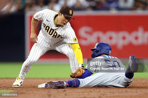 Ha-Seong Kim of the San Diego Padres is unable to make the tag in time as Mookie Betts of the Los Angeles Dodgers steals second base during the third...