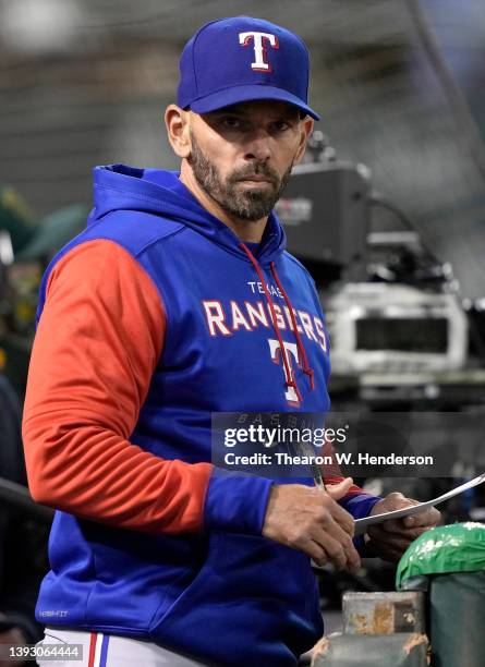 Manager Chris Woodward of the Texas Rangers looks on from the dugout against the Oakland Athletics in the bottom of the eighth inning at RingCentral...