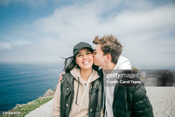 teenager heterosexual couple  kissing outdoors against blue sky - la coruña imagens e fotografias de stock