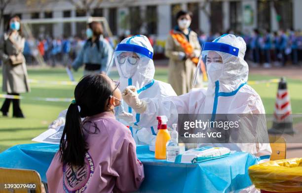 Medical worker collects swab samples from a student for COVID-19 nucleic acid test at a primary school on April 23, 2022 in Hohhot, Inner Mongolia...
