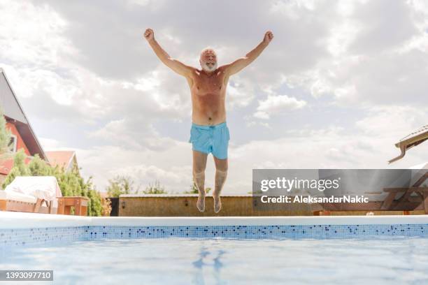älterer mann springt ins schwimmbad - jump in pool stock-fotos und bilder