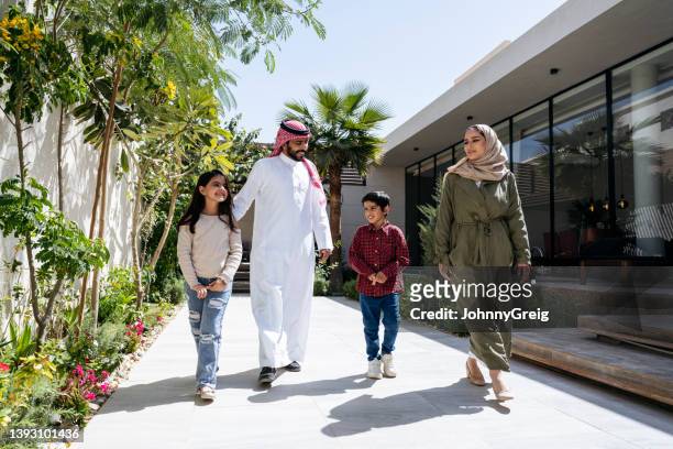 young saudi children walking outdoors with their parents - arab lifestyle stockfoto's en -beelden