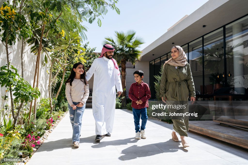 Young Saudi children walking outdoors with their parents