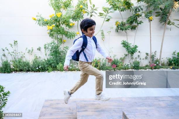 joven activo de oriente medio que regresa a casa de la escuela - khaki tan fotografías e imágenes de stock