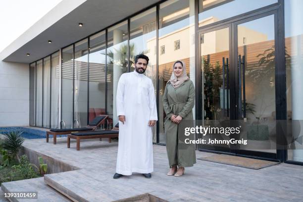 middle eastern couple in 20s and 30s outside family home - saudi home stock pictures, royalty-free photos & images